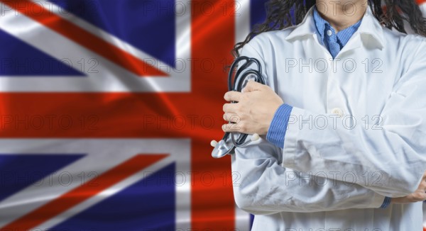 Healthcare professional with United Kingdom flag background. Professional doctor holding stethoscope on United Kingdom flag background