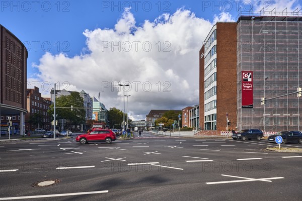 New town hall, general development, brick houses, brick architecture, commercial building, parking garage, renovation, scaffolding, construction site, square, road, road markings lanes, cars, lantern, blue sky, cumulus clouds, intersection Kaistraße with Stresemannplatz, Kiel, state capital, district-free city, Schleswig-Holstein, Germany
