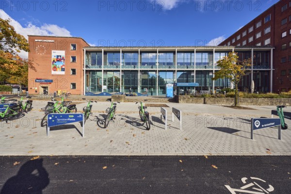 New town hall, tourist information, welcome center, brick building, modern building, glass façade, staircase, concrete paving walkway, e-scooter rental, sprat fleet bike sharing Kiel region, e-scooters, bicycles, blue sky, cumulus clouds, Andreas-Gayk-Straße, Stresemannplatz, Kiel, state capital, district-free city, Schleswig-Holstein, Germany