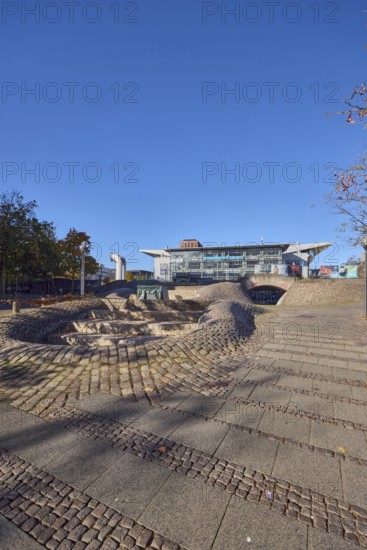 Fountain complex, multi-purpose hall Wunderino Arena or former Baltic Sea Hall, pedestrian zone, lantern, barrier bollard, footpath made of paving stones and cobblestones, trees, blue sky, cloudless, splash, Europaplatz, Kiel, state capital, district-free city, Schleswig-Holstein, Germany