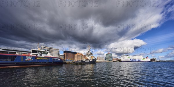 Kiel Fjord, port, pier, passenger ship, port and sea tug, ferry ship, general architecture, brick building, commercial building, water surface with small waves, blue sky, cumulus clouds, stratocumulus clouds, white and dark clouds, Kiel, state capital, district-free city, Schleswig-Holstein, Germany