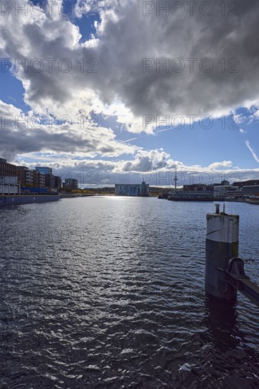 Kiel Fjord, harbor, duckdalben, quay, general architecture, modern buildings, television tower, water surface with small waves, sunny, back light, blue sky, cumulus clouds, stratocumulus clouds, cumulonimbus clouds, white and dark clouds, Willy-Brand-Ufer, Kaistraße, Kiel, state capital, district-free city, Schleswig-Holstein, Germany