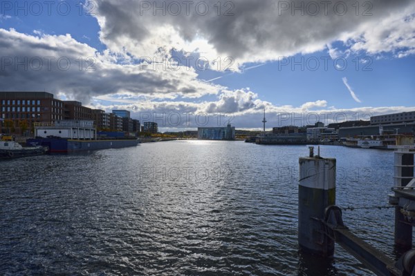 Kiel Fjord, harbor, duckdalben, quay, general architecture, modern buildings, television tower, water surface with small waves, sunny, back light, blue sky, cumulus clouds, stratocumulus clouds, cumulonimbus clouds, white and dark clouds, Willy-Brand-Ufer, Kaistraße, Kiel, state capital, district-free city, Schleswig-Holstein, Germany