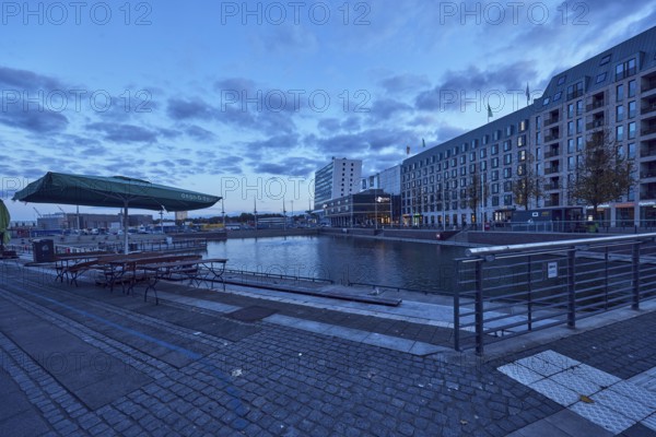 Boat harbor, water area, general architecture, commercial building, modern architecture, outdoor area of a restaurant, Dean and David Franchise GmbH, Hotel, Accor Group, Adagio Access, ibis Styles, casino, Schwedenkai ferry terminal, stainless steel railings, evening blue hour, blue evening sky, cumulus clouds, Wall, Holstenbrücke and Kaistraße streets, Kiel, state capital, district-free city, Schleswig-Holstein, Germany