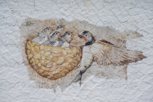 Swallow feeding her young in the nest, a painting on a farmhouse, Morschreuth, Upper Franconia, Bavaria, Germany