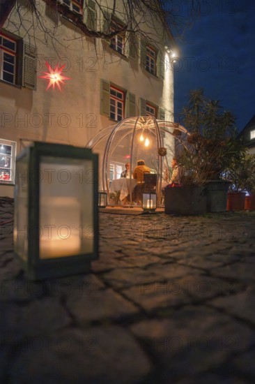 An illuminated dome at night on a stone path flanked by a large candle with windows in the background, Gastro Bubbles, Sindelfingen, Germany