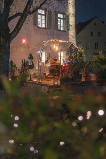 An illuminated outdoor dome at night with people eating, surrounded by plants and lights, Gastro Bubbles, Sindelfingen, Germany