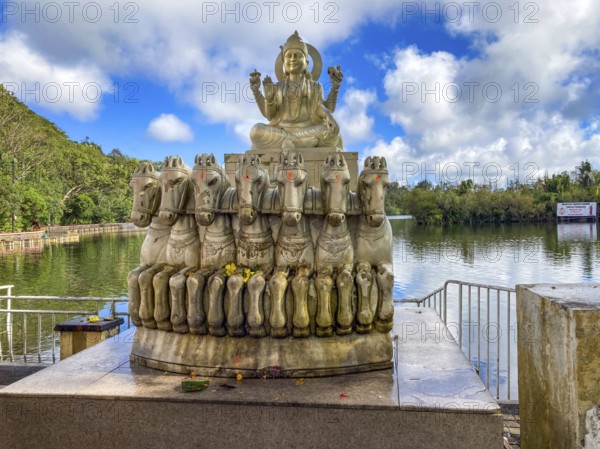 Sculpture statue of sun god Suraya in wagon is pulled from in front of seven 7 horses stands in behind in the background crater lake in crater of extinct volcano sacred Hindu lake Ganga Talao at religious site largest Hindu sanctuary for religion Hinduism outside India for believers Hindu Hindus, Grand Bassin, Le Pétrin, Mauritius
