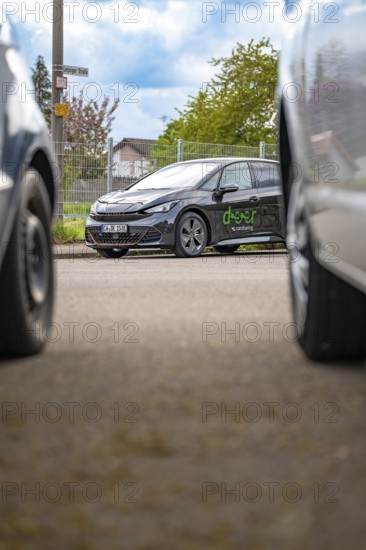 A modern car is parked between other vehicles on an urban road, Cupra electric car, e-car sharing, Calw, Germany