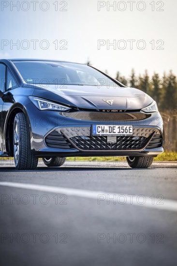 Close-up black car on a road with forest in the background, electric car Cupra, e-car sharing, Calw, Germany