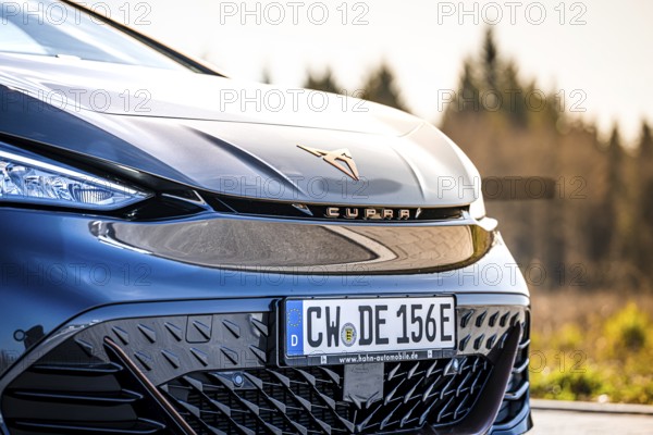 Detailed view of the front end of a stylish black car in front of a forest, electric car Cupra, e-car sharing, Calw, Germany