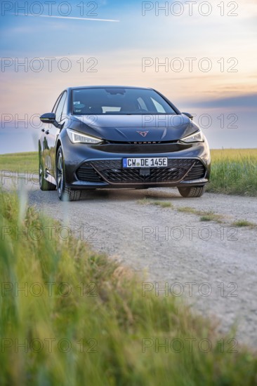 Car on a dirt road at dusk with fields in the foreground, electric car Cupra, e-car sharing, Calw, Germany