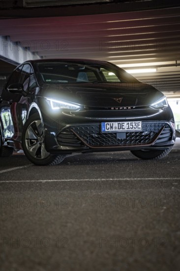Black car with dramatically glowing LEDs in a dark garage setting, Cupra electric car, e-car sharing, Calw, Germany