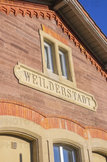 Brick building with Weilderstadt lettering under blue sky, Weil der Stadt railway station, Germany