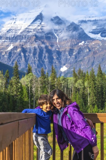 Mother and son are enjoying breathtaking views of mount robson, the highest peak in the canadian rockies, during a memorable family vacation in british columbia