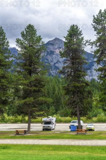 Recreational vehicles and cars parked in a campground near majestic mount robson, the highest peak in the canadian rockies, offering breathtaking views in british columbia
