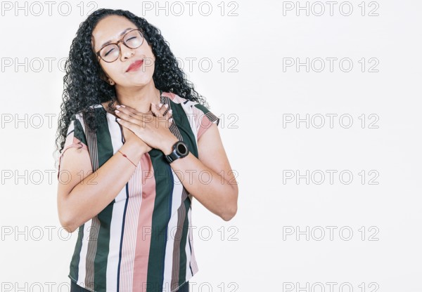Positive afro woman with lovely sincere smile feeling thankful, relaxed afro girl showing thank you gesture with hands on chest, Grateful people concept