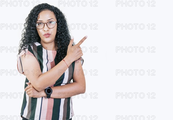 Beautiful afro young woman pointing an advertising to side. Surprised girl in glasses pointing to a banner to the side