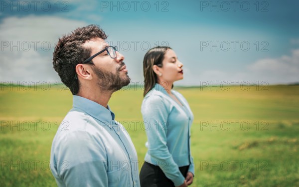 Young couple breathing fresh air in the field. Two relaxed people breathing fresh air in the countryside