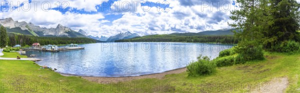 Breathtaking panorama of maligne lake, featuring crystal clear turquoise waters reflecting surrounding mountains and lush vegetation in jasper national park