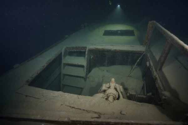 Diver examines a lediwreck, wreck of a lediship, ledi ship, cargo ship for mass freight, bulk cargo, at night in Lake Walen. Tauchplatz Känzeli, Mols, Canton of St. Gallen, Switzerland
