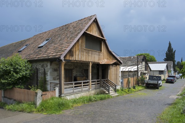 Rural scenery with wooden houses and parked cars under a cloudy sky, Schwabenstraße, village founded by Caucasian Germans, Assureti, Elizabeth Valley, Lower Kartli region, Georgia