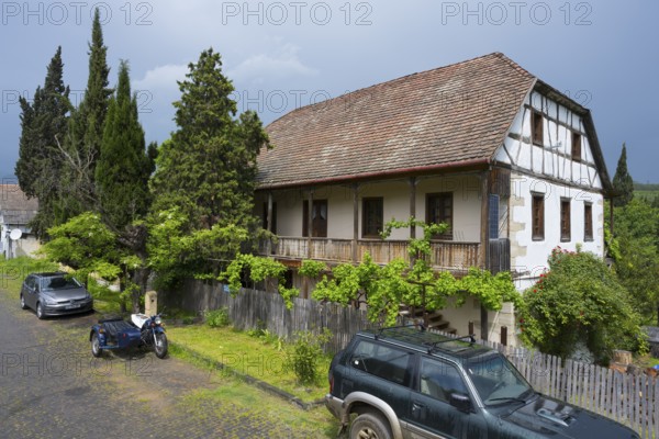 Half-timbered rural house with parked car and motorbike on a cobblestone street, Schwabenstraße 15, village founded by Caucasian Germans, Assureti, Elizabeth Valley, Lower Kartli region, Georgia