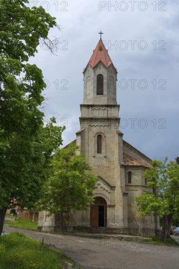 Large church with Gothic bell tower and red roof tiles surrounded by green trees, German Evangelical Lutheran Church of the Redeemer, Schwabenstraße, village founded by Caucasian Germans, Assureti, Elizabeth Valley, Lower Kartli region, Georgia