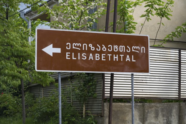 Brown road sign points towards Elisabeththal in Georgian and English letters, village founded by Caucasian Germans, Asureti, Asureti, Elizabeth Valley, Lower Kartli region, Georgia