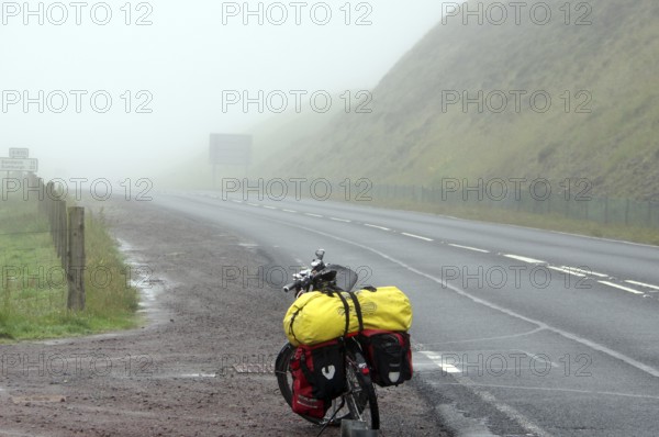 Bicycle with luggage on a foggy and deserted country road, cycle tourism, adventure, Shetlands, Shetland Islands, Scotland, Great Britain