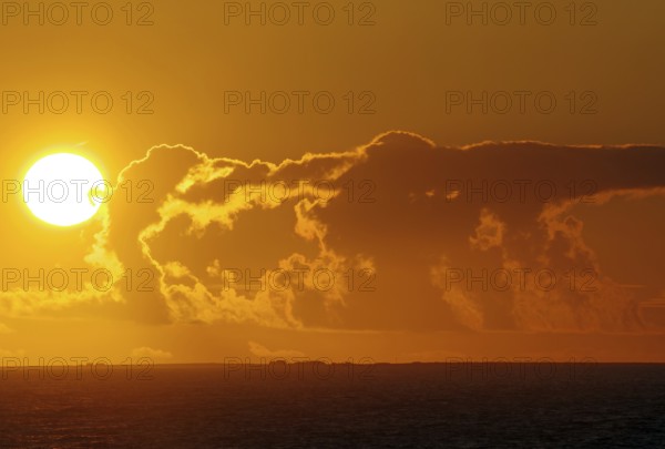 A dramatic sunset over the sea with bright orange clouds, Orkneys, Orkney Islands, Scotland, United Kingdom