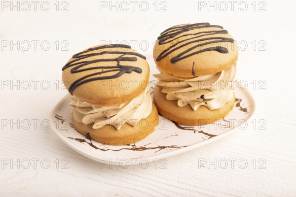 Caramel Cream Cakes on white wooden background, side view, close up