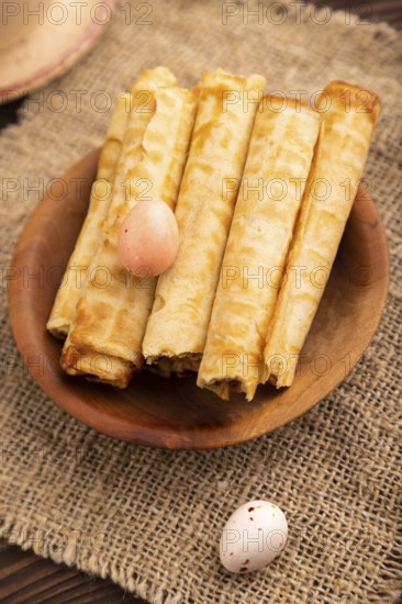 Waffles with caramel on brown wooden background and linen textile, cup of coffee, side view, selective focus
