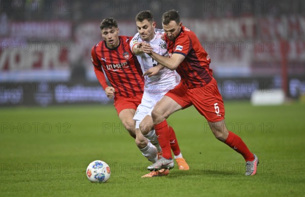 One-on-one, action Josip Stanisic FC Bayern Munich FCB (44) (centre) against Benedikt Gimber 1. FC Heidenheim 1846 FCH (05) Luca Kerber 1. FC Heidenheim 1846 FCH (20) Voith-Arena, Heidenheim, Baden-Württemberg, Germany
