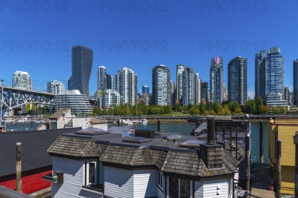 Granville island market with vancouver skyline rising in background on a sunny day, showcasing the vibrant cityscape and waterfront community