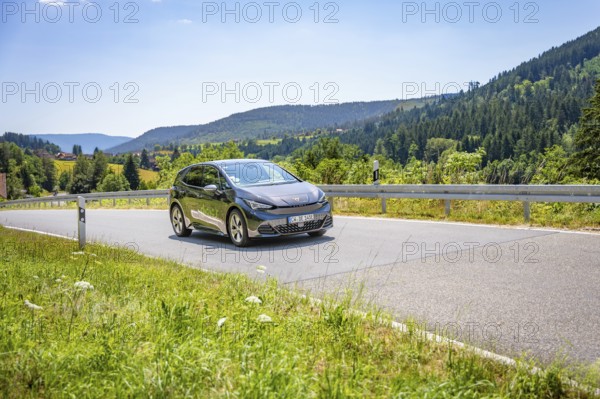 Car driving on a winding road in a mountainous landscape, Deer E-car sharing, Cupra electric car, Germany