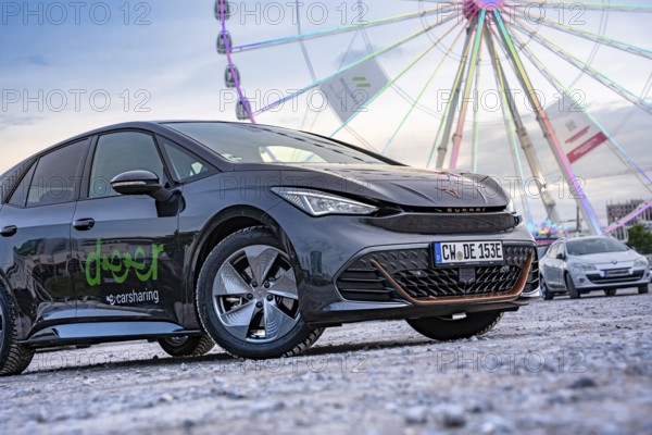 Modern cars in front of a big Ferris wheel at a trade show, Deer E-Car Sharing, Cupra electric car, Germany
