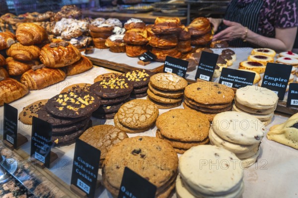 Freshly baked cookies and pastries are neatly arranged and labeled with prices in a bakery display case in vancouver, british columbia, tempting customers with their delicious aroma and appearance