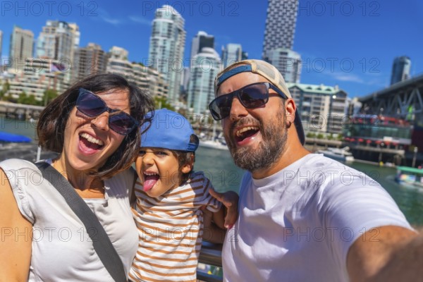 Happy family enjoying a sunny summer day while taking a selfie with the stunning vancouver, british columbia skyline in the background, capturing joyful moments together