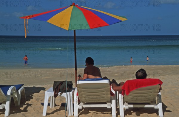 People holding umbrellas and sun loungers on Karon Beach, two years in front of the tsunami, Ko Phuket, Thailand, December 2002, vintage, retro, old, historic