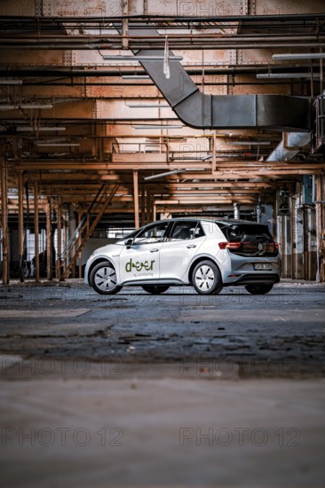 A car in a factory surrounded by structural steel girders and industrial ambiance, Deer E-Car Sharing, Motorworld Rüsselsheim, Germany