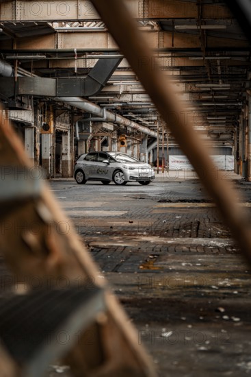 A car is parked in an abandoned factory building that exudes a rusty, mysterious charm, Deer E-Car Sharing, Motorworld Rüsselsheim, Germany