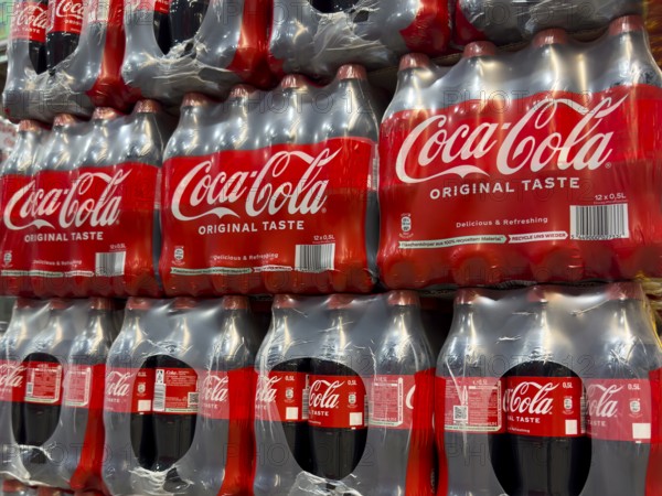 0.5 half liter plastic PET bottles stacked in plastic packs with sugary caffeinated beverage soft drink Coca Cola, Germany