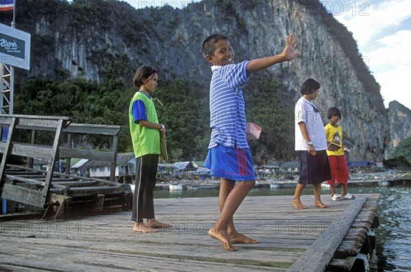 Children, little boy waving in the stilt village of Ko Pannyi in Phangnga Bay near Ko Phuket, two years in front of the tsunami, Thailand, December 2002, vintage, retro, old, historic
