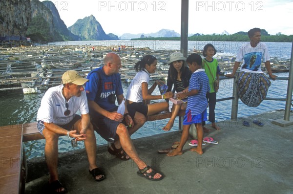 Young boy in the stilt village of Ko Pannyi in Phangnga Bay near Ko Phuket selling souvenirs to tourists, two years in front of the tsunami, Thailand, December 2002, vintage, retro, old, historic
