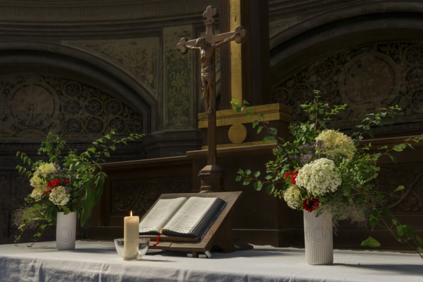 Decorated church altar with Jesus cross and Bible with burning candle