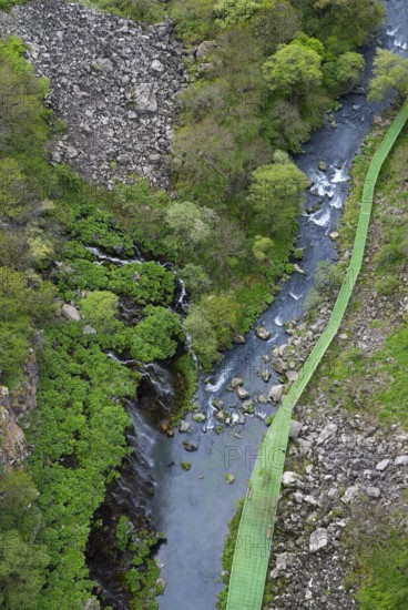 Narrow bridge across a river amidst forest and rocky terrain, Dashbashi gorge and waterfall, Khrami River, Tsalka Nature Reserve, Kartli, Georgia