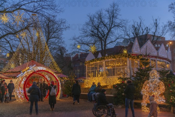 Christmas market on Holstenplatz in Kiel, city center, trees, shops, pedestrian zone, early evening, stalls, visitors, glowing stars, lights, Christmas decorations, fun, festive atmosphere, Christian festival, Santa Claus, light tunnel, Schleswig-Holstein, Germany