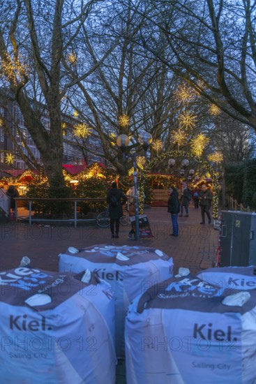 Safety measures for the Christmas market on Holstenplatz in Kiel, city center, Christian festival, lettering, barrier, sandbags, barriers, protection, fear, danger, evening, glowing stars, booths, trees, pedestrian zone, Christmas decorations, visitors, Schleswig-Holstein, Germany