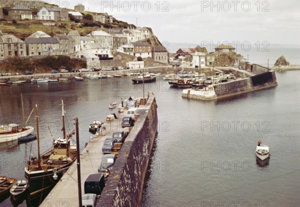 Boats at moorings in the harbour at seaside fishing village of Mevagissey, Cornwall, England, UK c 1960